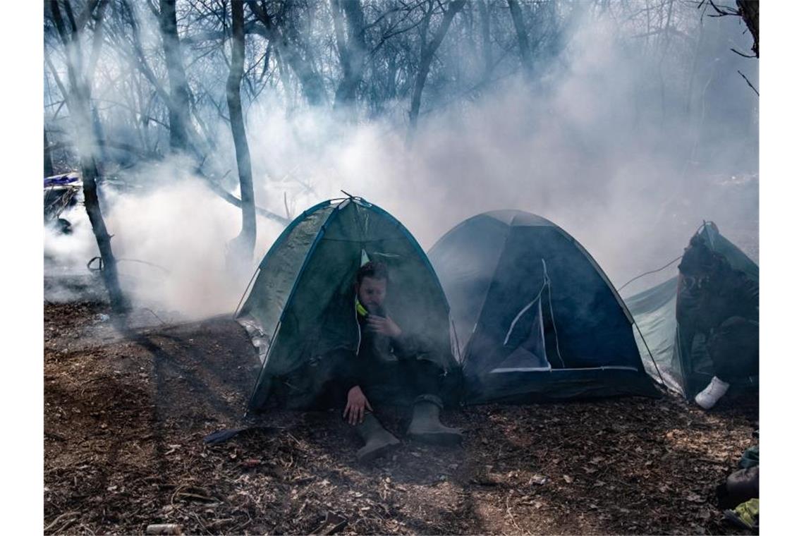 Ein Migrant sitzt in einem Zelt auf der türkischen Seite der Grenze. Foto: Yasin Akgul/dpa