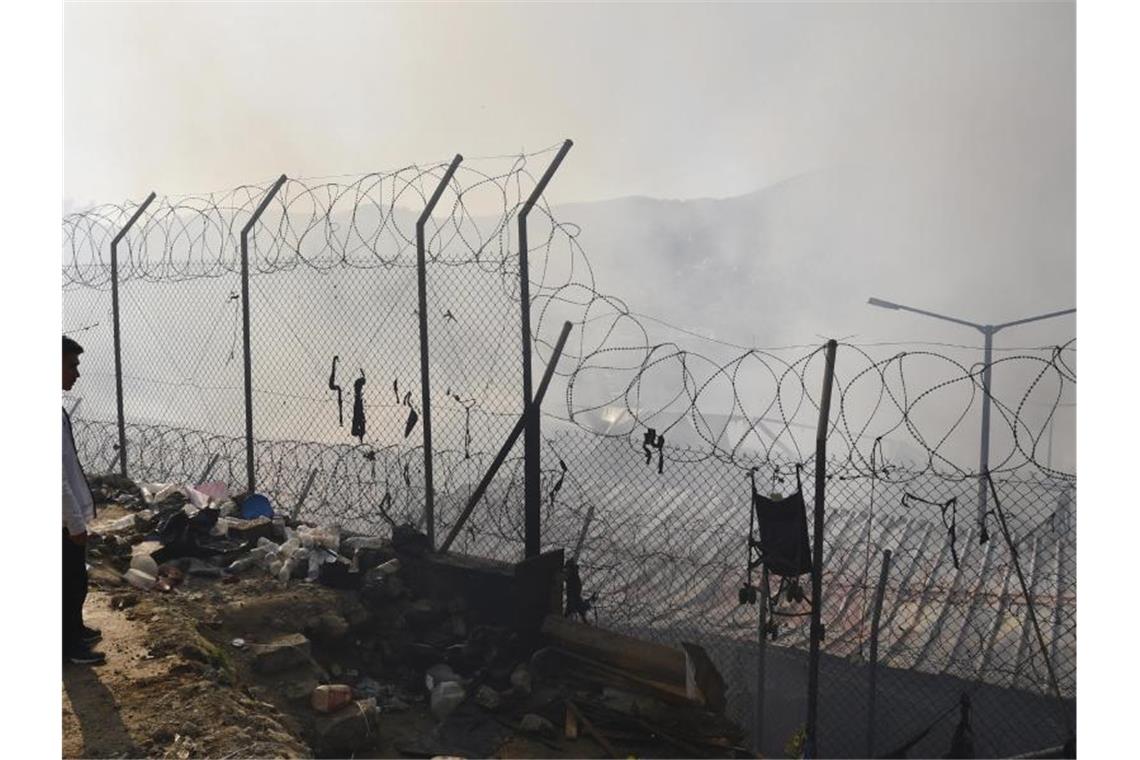 Feuer im Registrierlager von Samos Ein Migrant steht vor einem Flüchtlingslager nach einem Brand auf der ostägäischen Insel Samos in der Ägäis. Hier leben zurzeit rund 3800 Menschen. Foto: Michael Svarnias/AP/dpa