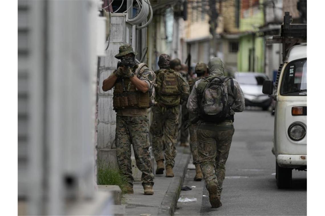 Ein Militärpolizist der Spezialeinheiten richtet seine Waffe während eines Einsatzes gegen mutmaßliche Drogenhändler in der Favela Vila Cruzeiro in Rio de Janeiro. Foto: Silvia Izquierdo/AP/dpa