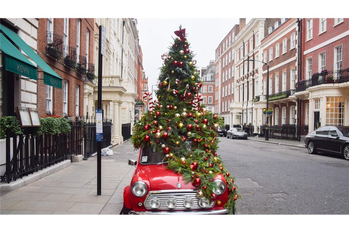 Ein mit einem Weihnachtsbaum geschmückter Mini steht in London auf der Straße.