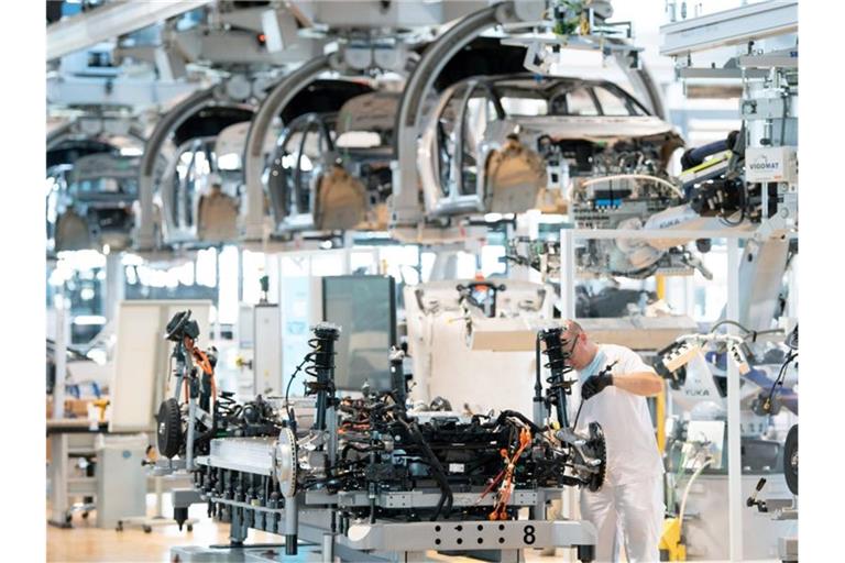 Ein Mitarbeiter arbeitet an der Karosserie eines E-Autos. Die Verdopplung der Rohstoffkosten und fehlende Elektronikchips bremsen derzeit die Autoindustrie aus. Foto: Sebastian Kahnert/dpa-Zentralbild/dpa