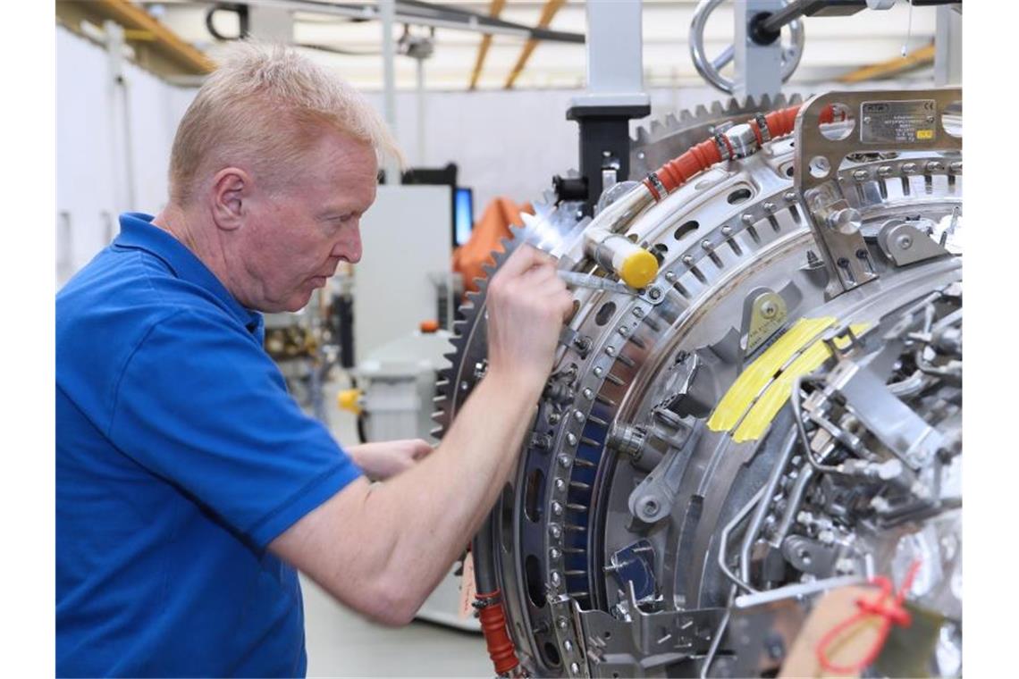 Ein Mitarbeiter arbeitet in einem Werk der MTU Aero Engines AG an einer Flugzeug-Turbine. Foto: -/MTU Aero Engines AG/dpa
