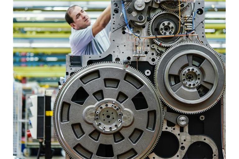 Ein Mitarbeiter arbeitet in einer Werkshalle an einem Druckwerk. Foto: Uwe Anspach/dpa/Symbolbild