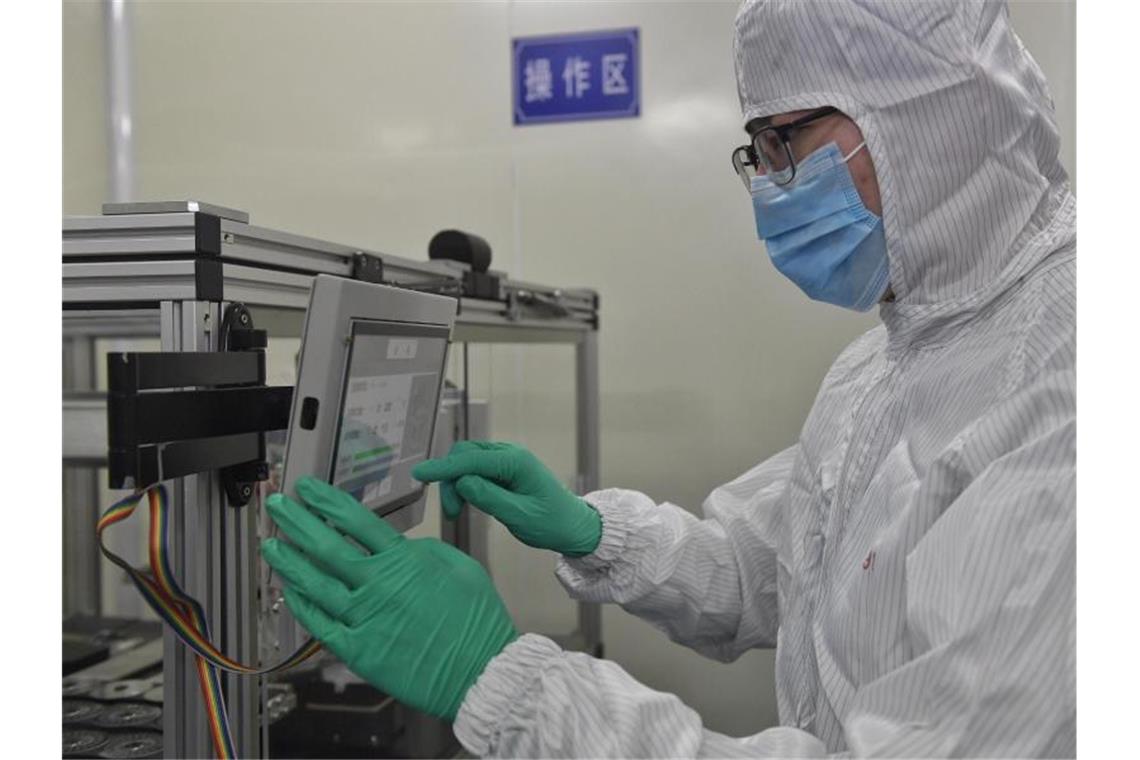Ein Mitarbeiter bearbeitet einen Nukleinsäuretestchip in der Anlage eines Biotech-Unternehmens. Ein neu entwickelter Nukleinsäuretestchip, der sechs Atemwegsviren, einschließlich des neuartigen Coronavirus, nachweisen und unterscheiden kann, wurde von der nationalen chinesischen Arzneimittelbehörde genehmigt. Foto: Liu Kun/XinHua/dpa