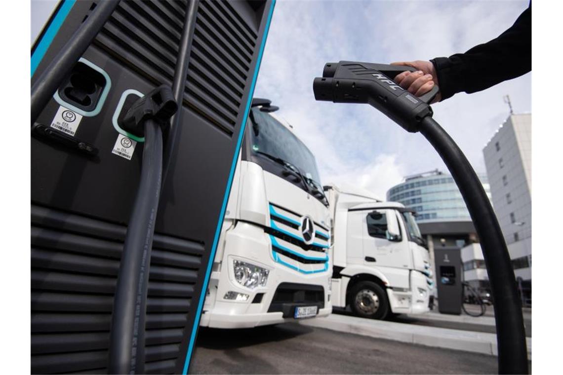 Daimler Truck stellt Geschäfte in Russland ein Ein Mitarbeiter der Daimler AG einen Ladestecker an einer Elektro-Ladesäule in der Hand. Foto: Marijan Murat/dpa/Archivbild
