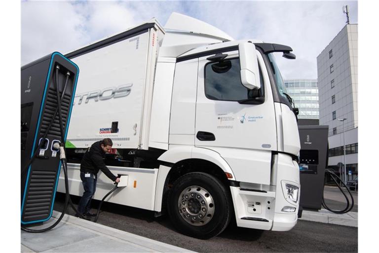 Ein Mitarbeiter der Daimler AG steckt einen Ladestecker in einen elektrisch angetriebenen Mercedes-Benz eActros. Foto: Marijan Murat/dpa/Archivbild
