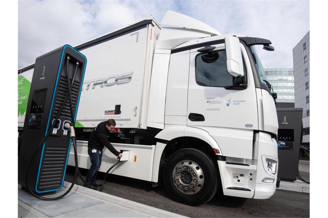 Ein Mitarbeiter der Daimler AG steckt einen Ladestecker in einen elektrisch angetriebenen Mercedes-Benz eActros. Foto: Marijan Murat/dpa