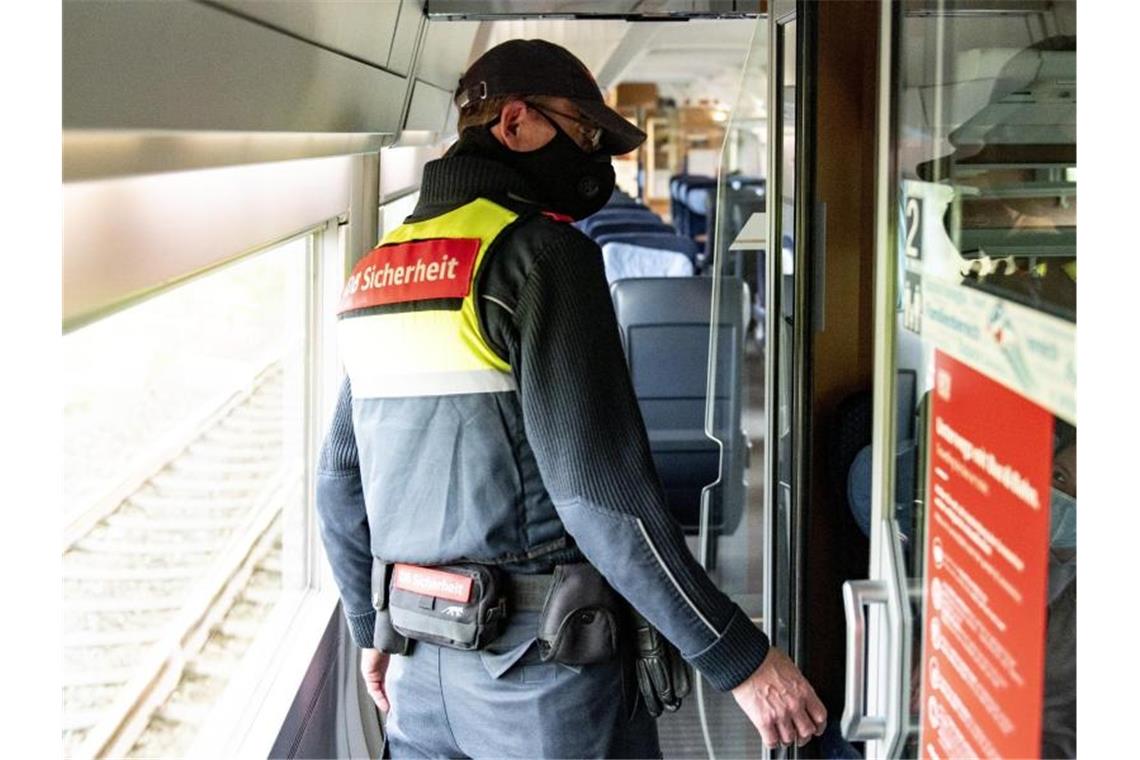 Ein Mitarbeiter der DB-Sicherheit kontrolliert in einem ICE, ob die Fahrgäste einen Mund-Nasen-Schutz tragen. Foto: Axel Heimken/dpa