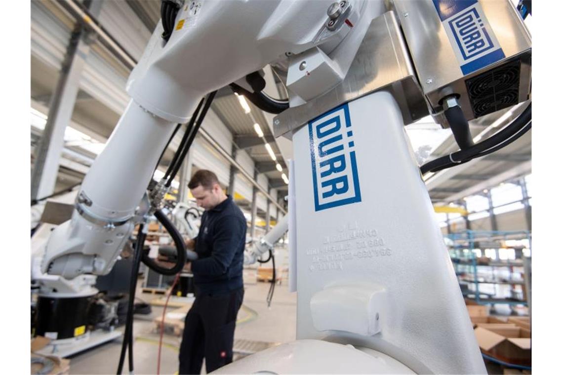 Ein Mitarbeiter der Dürr AG programmiert einen Sealing-Roboter. Foto: Marijan Murat/dpa/Archivbild