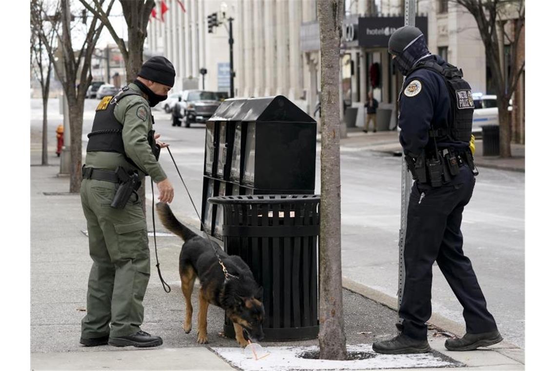 Heftige Explosion mit Vorwarnung: FBI ermittelt in Nashville Ein Mitarbeiter der Hundestaffel (K9) sucht das Gebiet mit Bombenspürhunden ab, um mögliche weitere Explosionen auszuschließen. Foto: Mark Humphrey/AP/dpa