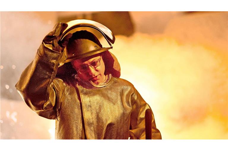 Ein Mitarbeiter der Salzgitter AG steht – gut geschützt – vor einem Hochofen.