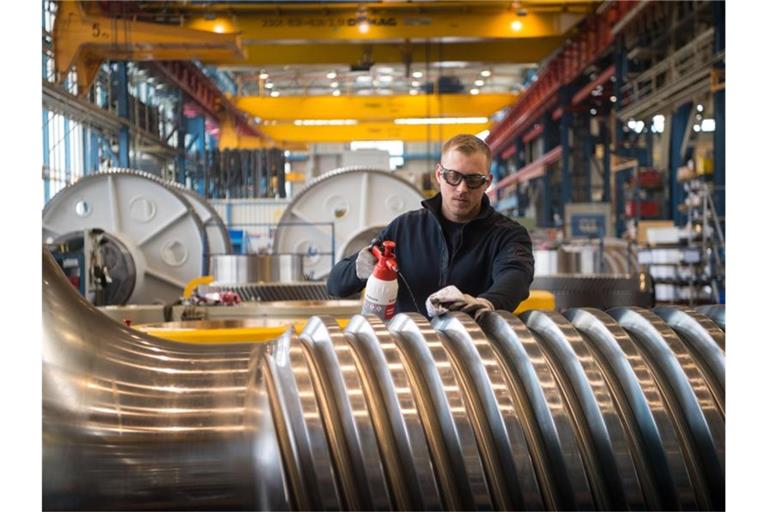 Ein Mitarbeiter der Schuler AG reinigt eine Antriebsspindel für eine Schmiedepresse. Foto: Marijan Murat/dpa/Archivbild