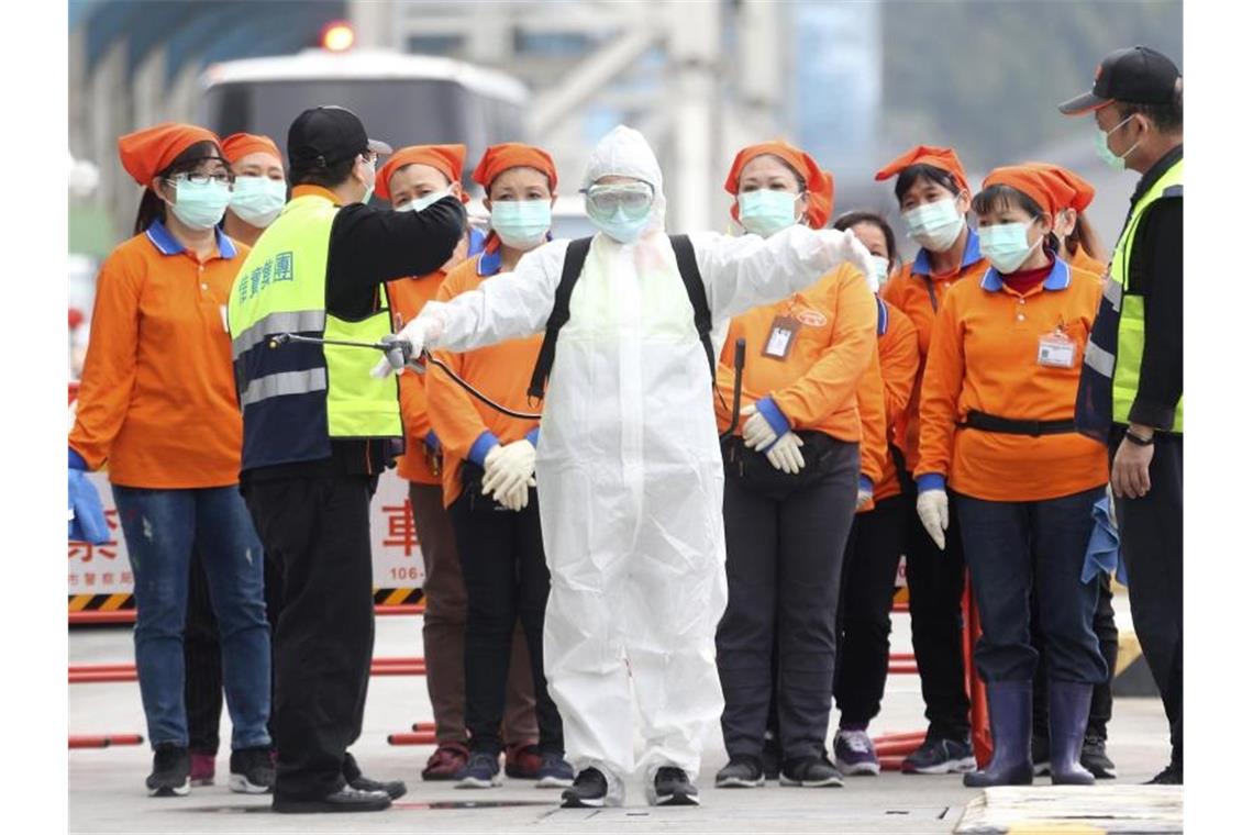 Ein Mitarbeiter der Seuchenbekämpfung steht bereit, um im Hafen von Taiwans Hauptstadt Taipeh an Bord des Kreuzfahrtschiffes „SuperStar Aquarius“ zu gehen. Foto: Chiang Ying-Ying/AP/dpa