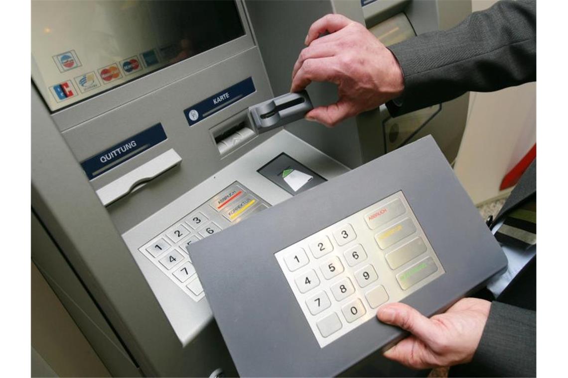 Ein Mitarbeiter der Sparkasse Koblenz demonstriert an einem Geldautomaten die „Skimming“- Technik. Foto: Thomas Frey/dpa