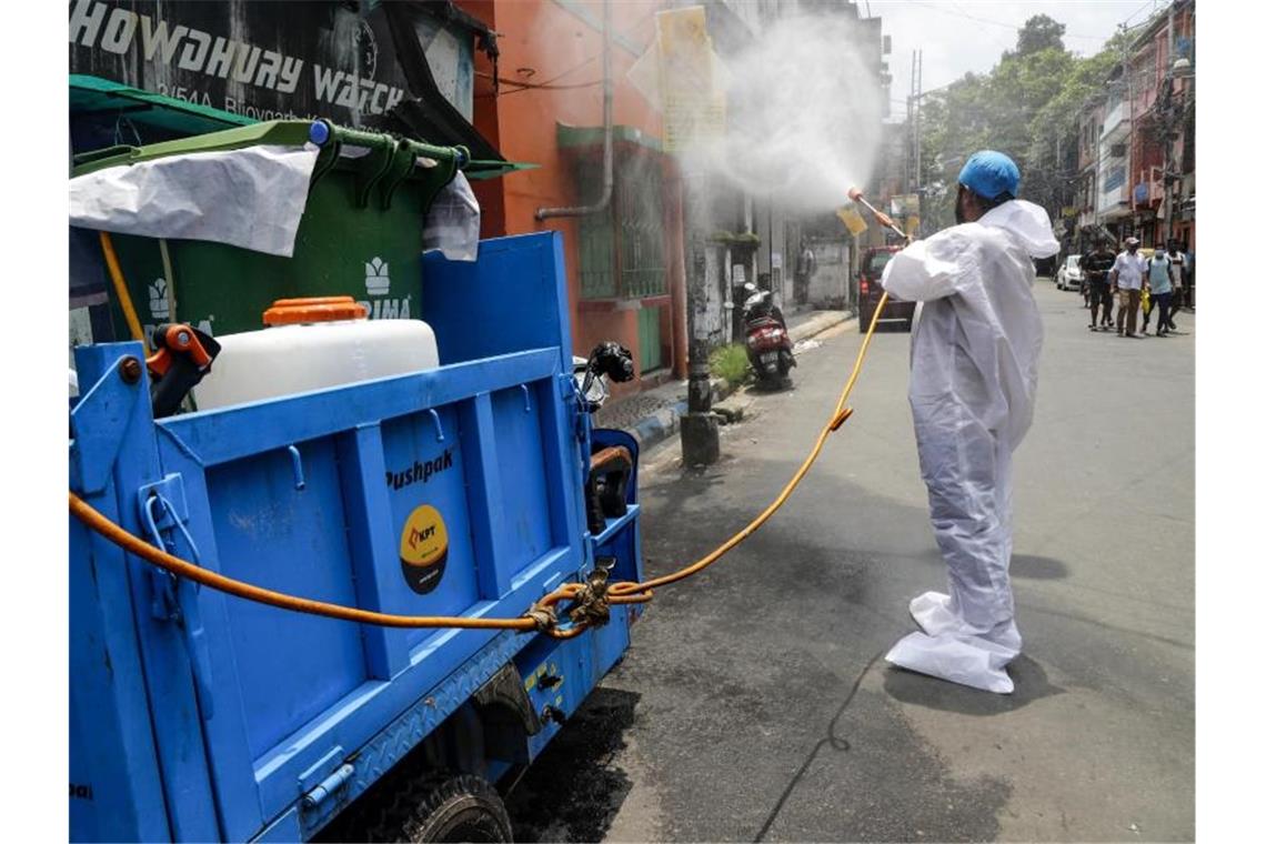 Indiens Wirtschaftskraft bricht ein Ein Mitarbeiter der Stadt desinfiziert in Kolkata eine Straße. Ein strikter Lockdown hatte die wirtschaftlichen Aktivitäten in Indien zwischenzeitlich nahezu zum Erliegen gebracht. Foto: Bikas Das/AP/dpa