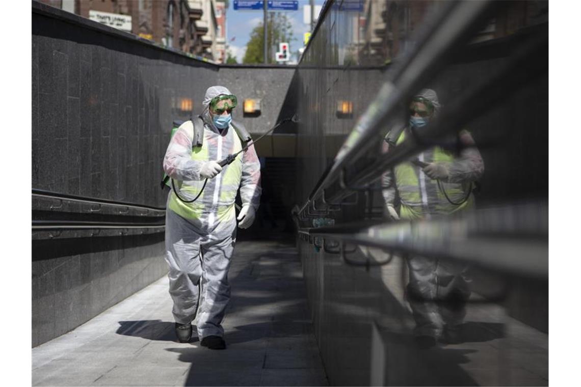 Ein Mitarbeiter der Stadtverwaltung desinfiziert eine Fußgängerpassage in Moskau. Foto: Alexander Zemlianichenko/XinHua/dpa