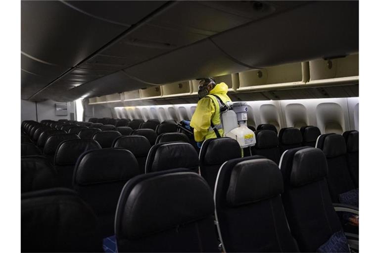 Ein Mitarbeiter des Flughafens Paris-Charles-de-Gaulle desinfiziert den Passagierraum eines Air France-Maschine. Foto: Ian Langsdon/EPA POOL/AP/dpa