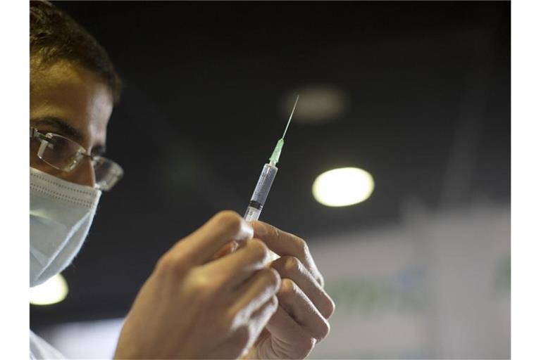 Ein Mitarbeiter des Gesundheitswesens bereitet in Jerusalem eine Spritze für eine Impfung gegen das Coronavirus vor. Foto: Maya Alleruzzo/AP/dpa