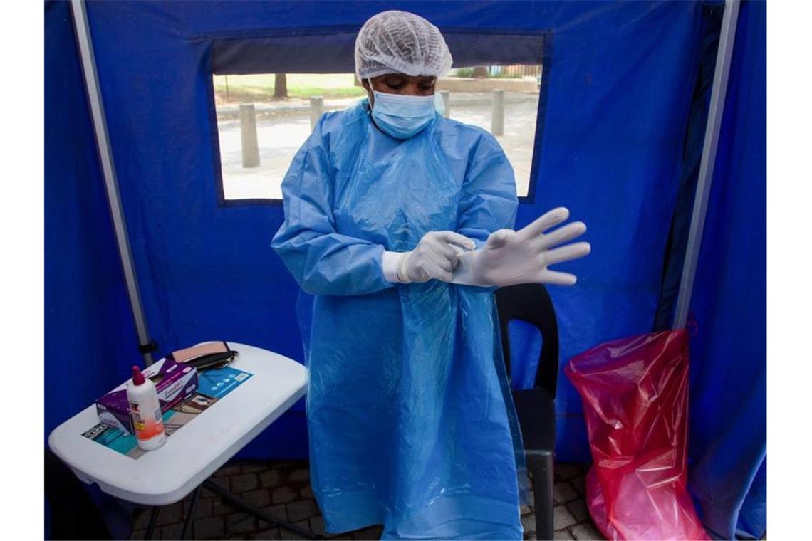 Studien deuten auf milden Omikron-Verlauf Ein Mitarbeiter des Gesundheitswesens in Südafrika bereitet sich auf einen Corona-Test vor. Foto: Denis Farrell/AP/dpa