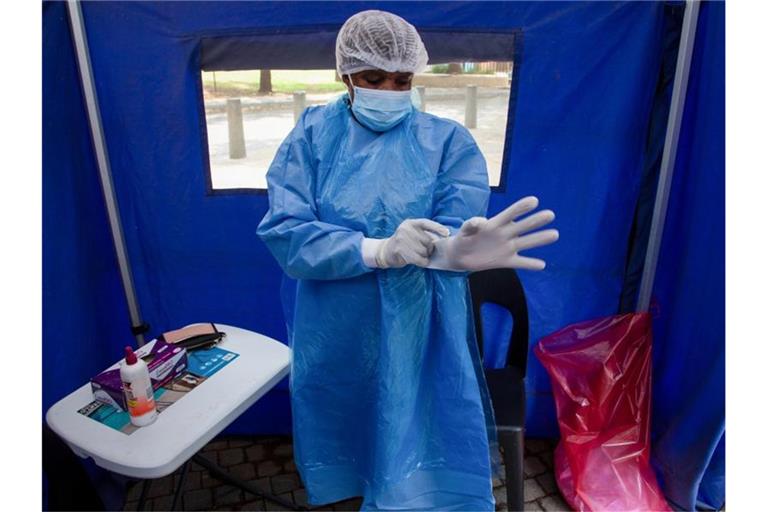 Ein Mitarbeiter des Gesundheitswesens in Südafrika bereitet sich auf einen Corona-Test vor. Foto: Denis Farrell/AP/dpa