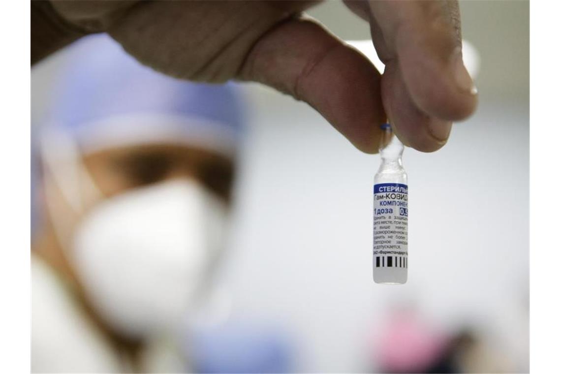 Ein Mitarbeiter des Gesundheitswesens zeigt eine Dosis des Corona-Impfstoffes Sputnik V. Foto: Jesus Vargas/dpa/Symbolbild