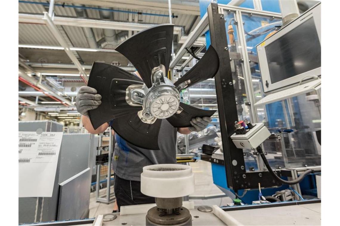 Ein Mitarbeiter des Herstellers von Ventilatoren und Elektromotoren, ebm-papst montiert einen Lüfter. Foto: Daniel Maurer/Archivbild