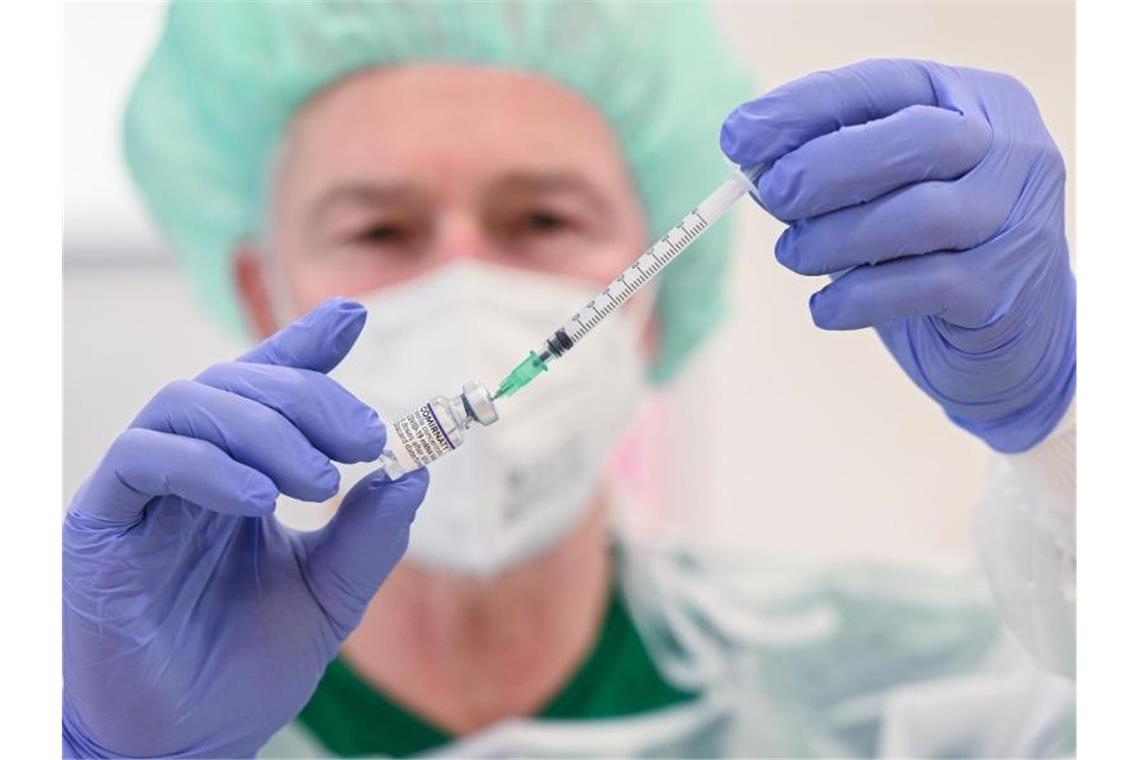 Impftempo sinkt - Rund 175.000 Dosen am Donnerstag Ein Mitarbeiter des Klinikums Stuttgart bereitet in einer Impfstation eine Spritze für eine Impfung gegen das Coronavirus vor. Foto: Bernd Weißbrod/dpa