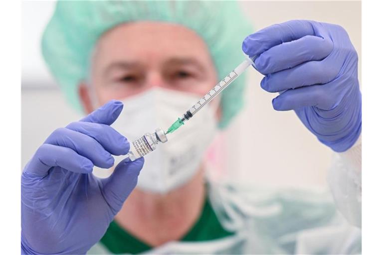 Ein Mitarbeiter des Klinikums Stuttgart bereitet in einer Impfstation eine Spritze für eine Impfung gegen das Coronavirus vor. Foto: Bernd Weißbrod/dpa