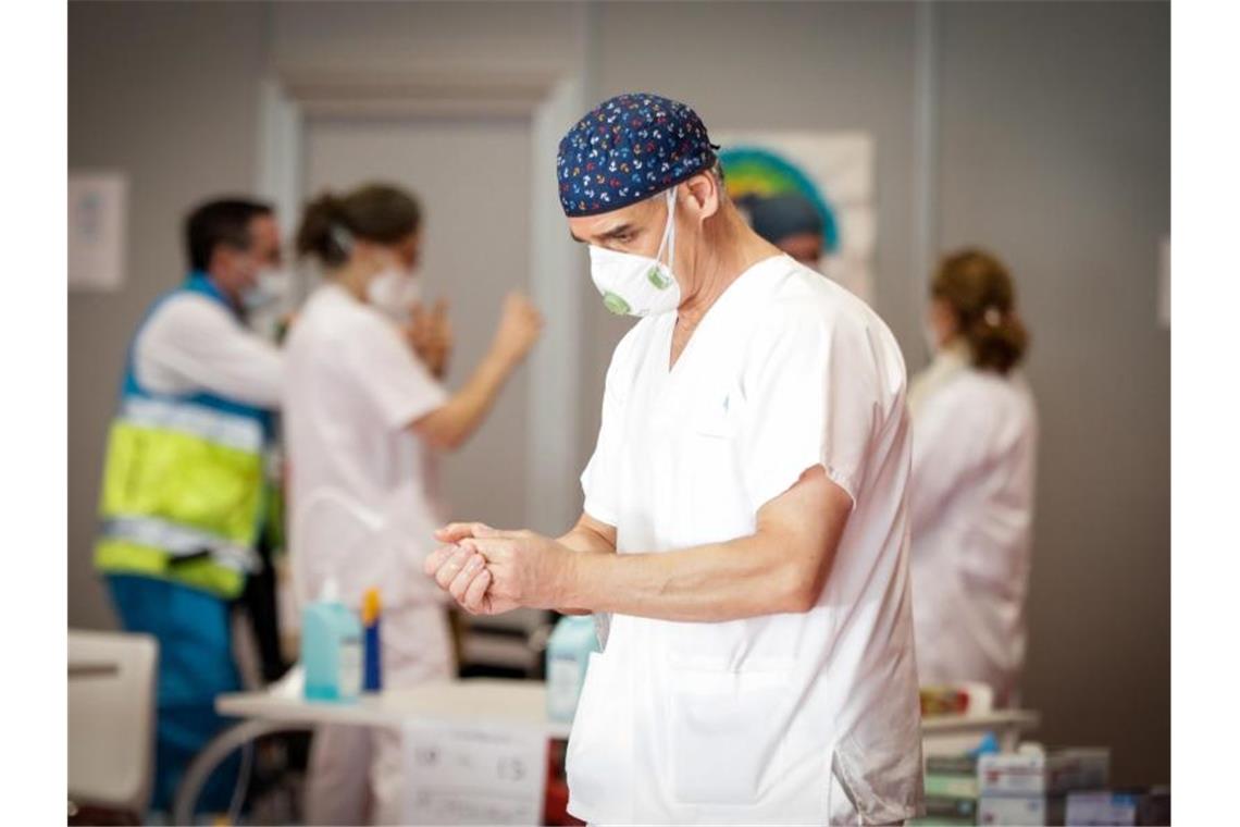 Ein Mitarbeiter des spanischen Gesundheitswesens desinfiziert seine Hände. Foto: Jesús Hellín/Europa Press/dpa
