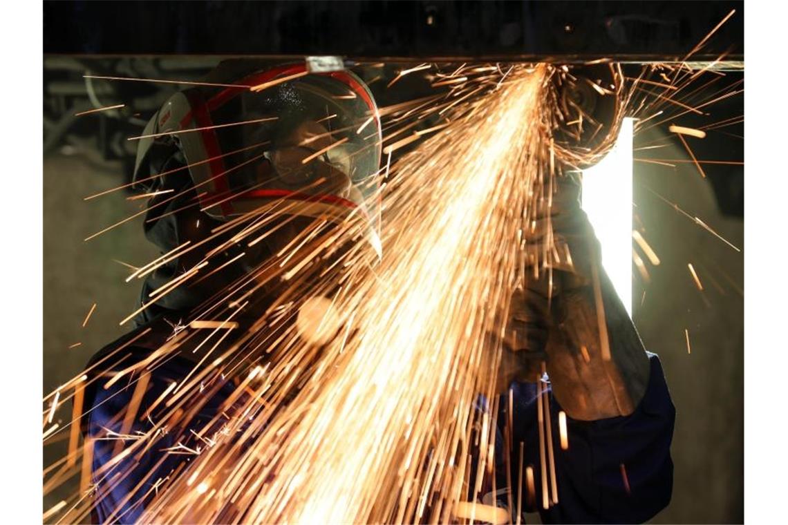 Ein Mitarbeiter eines Maschinenbauunternehmens schneidet Metallteile. Die Bestellungen bei Deutschlands Maschinenbauern gingen im April um 31 Prozent zurück. Foto: Jan Woitas/dpa-Zentralbild/dpa