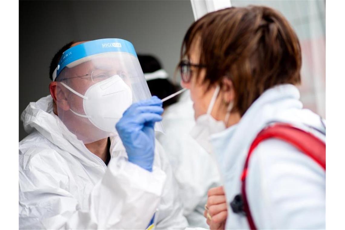 Bundesweite 7-Tage-Inzidenz nähert sich der 100 Ein Mitarbeiter eines Testcenters führt einen Test auf das Coronavirus durch. Die Zahl der Neuinfektionen in Deutschland sinkt weiter. Foto: Hauke-Christian Dittrich/dpa