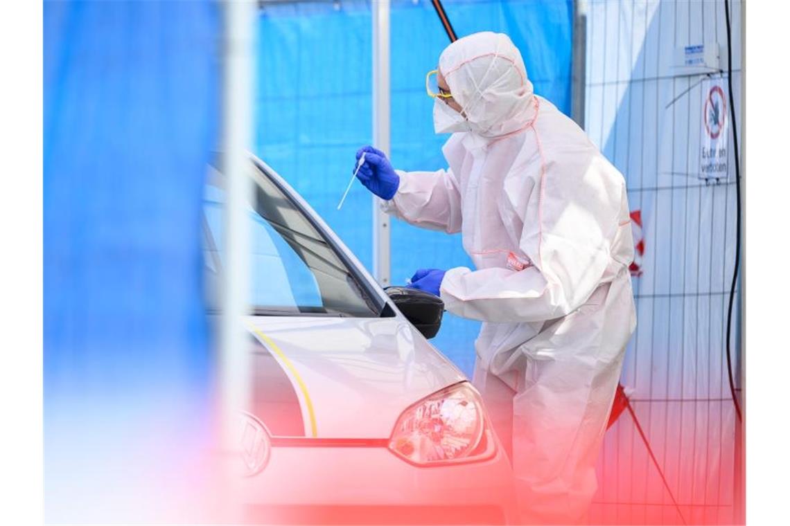 Ein Mitarbeiter führt in einem Abstrichzentrum einen Test auf das Coronavirus Sars-Cov-2 durch. Foto: Sebastian Gollnow/dpa/Symbolbild