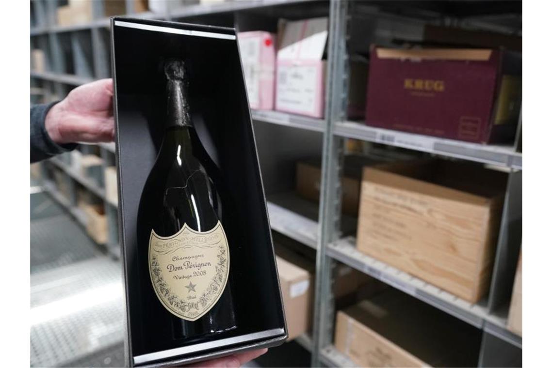 Onlinetrend treibt Umsatz und Gewinn bei Hawesko Ein Mitarbeiter hält eine Champagne-Flaschen des Weinhändlers Hawesko in der Hand. Foto: Marcus Brandt/dpa/Symbolbild