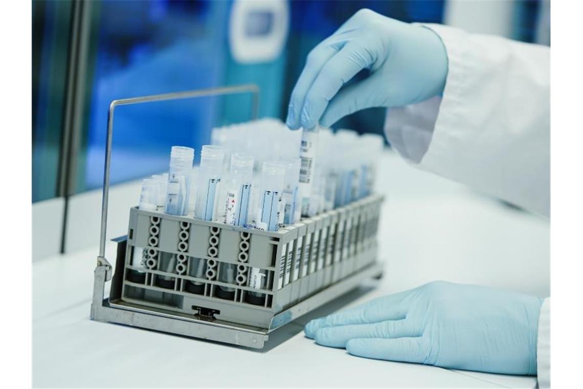 Moderna startet klinische Studie zu Omikron-Impfstoff Ein Mitarbeiter hält in einem Coronatest-Labor PCR-Teströhrchen in den Händen. Foto: Uwe Anspach/dpa
