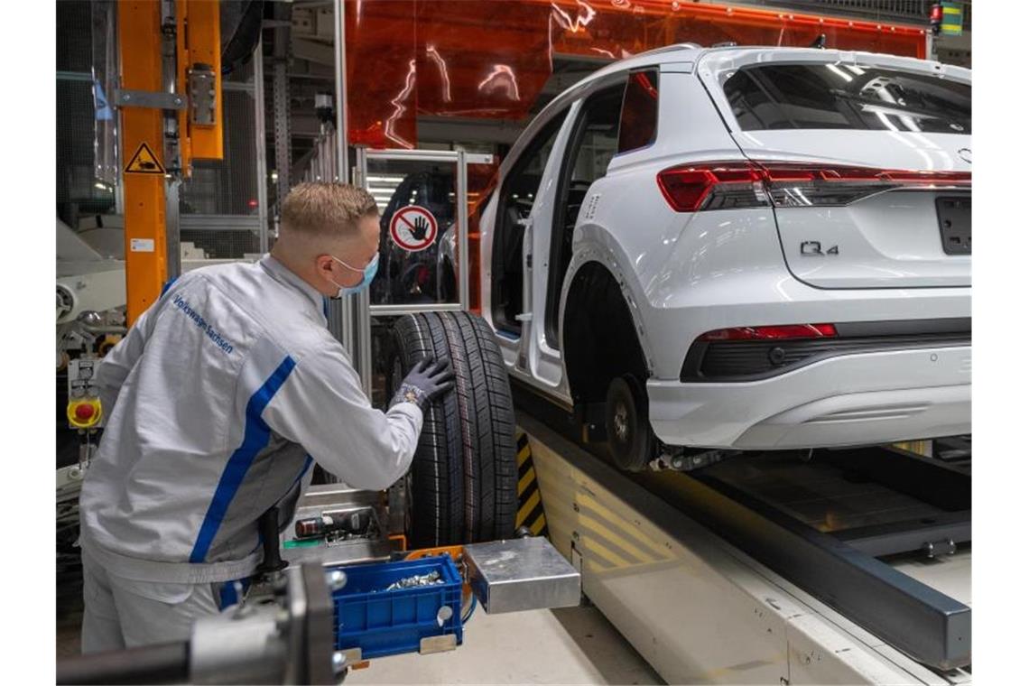Ein Mitarbeiter im Volkswagen-Werk in Zwickau montiert einen Audi Q4 e-tron. Foto: Hendrik Schmidt/dpa-Zentralbild/dpa