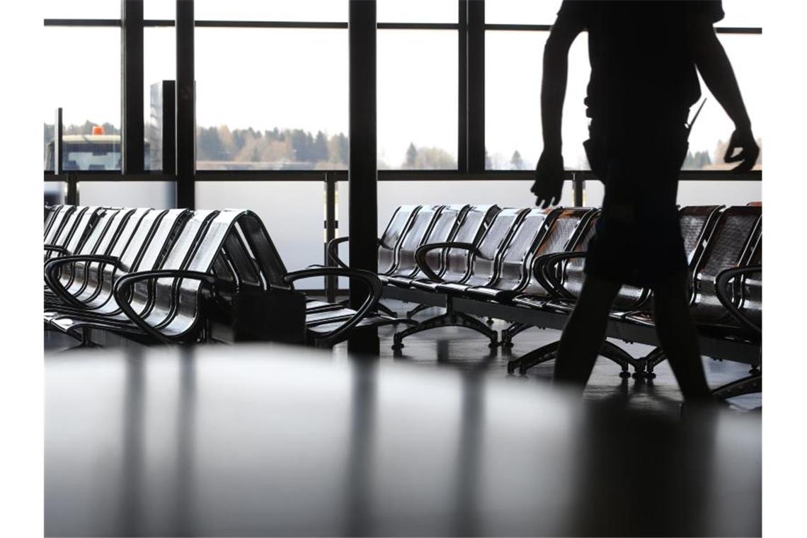 Sicherheitsbranche: Vorschriften verschärfen die Krise Ein Mitarbeiter läuft vor den menschenleeren Stuhlreihen im Sicherheitsbereich des geschlossenen Allgäu-Airports. Foto: Karl-Josef Hildenbrand/dpa