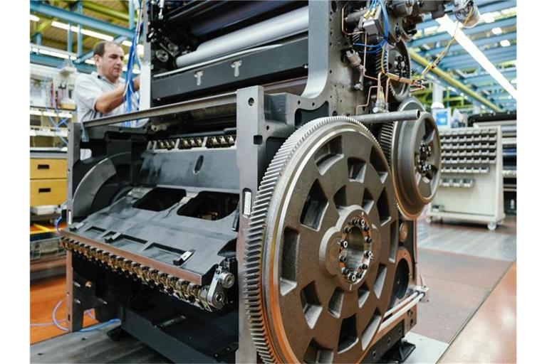 Ein Mitarbeiter montiert in einer Werkshalle am Stammsitz der Heidelberger Druckmaschinen AG ein Druckwerk. Foto: Uwe Anspach/dpa