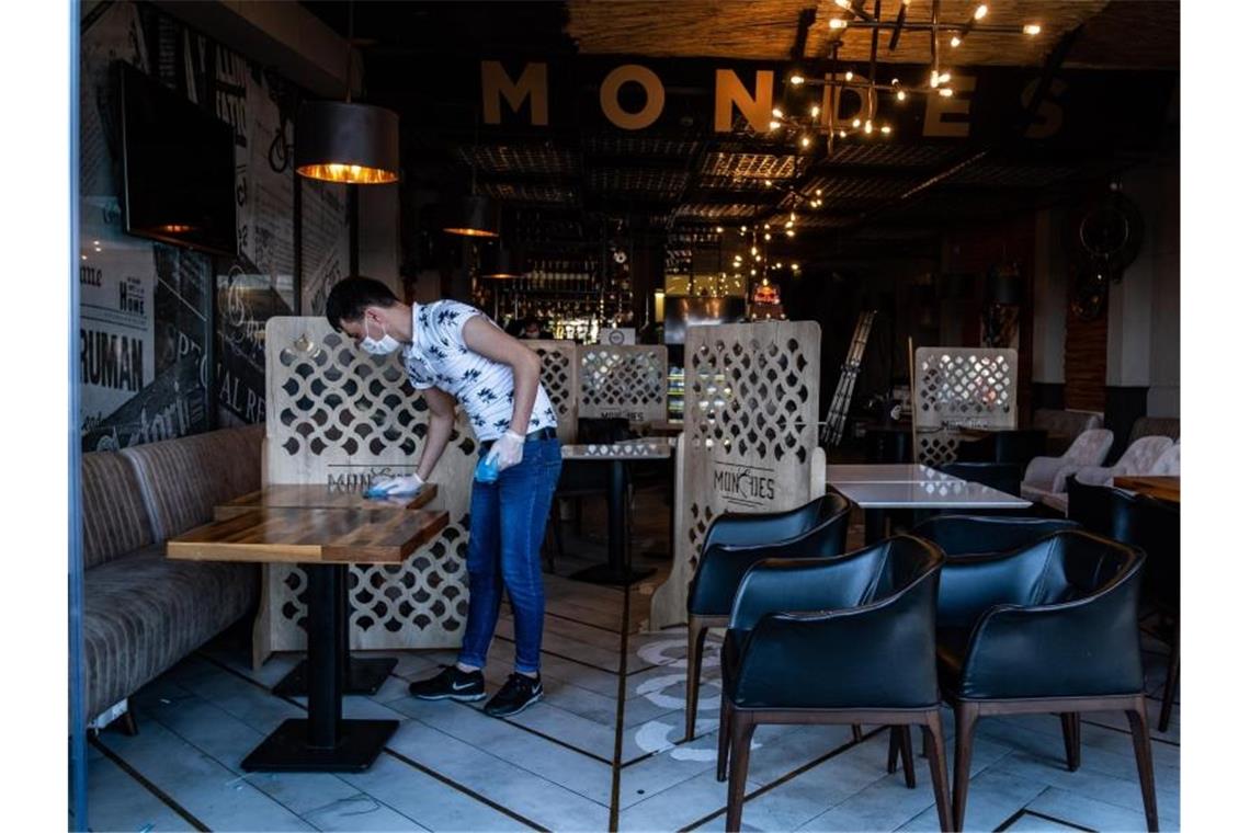 Trotz Sorgen vor zweiter Corona-Welle: Lockerungen weltweit Ein Mitarbeiter reinigt die Tische eines Restaurants in Istanbul vor der Wiedereröffnung. Foto: Yasin Akgul/XinHua/dpa