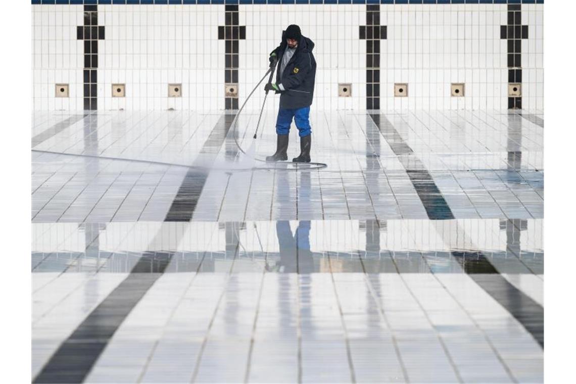 Ein Mitarbeiter reinigt ein Becken im Inselbad Untertürkheim in Stuttgart. Foto: Marijan Murat/dpa