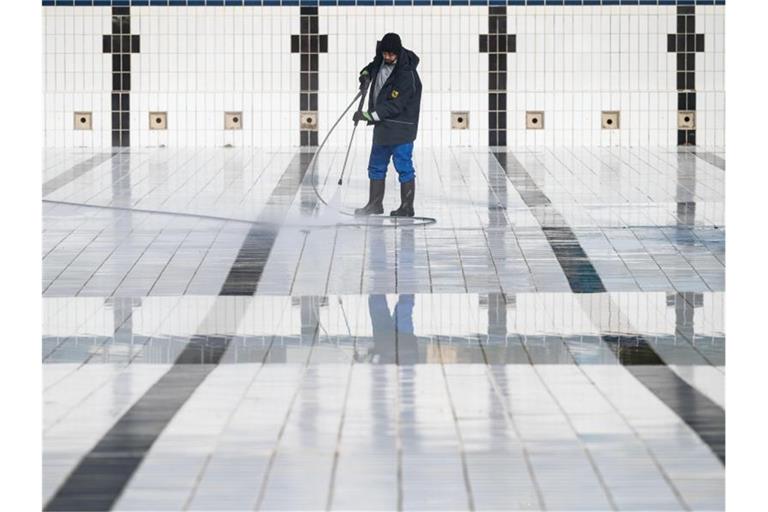 Ein Mitarbeiter reinigt ein Becken im Inselbad Untertürkheim in Stuttgart. Foto: Marijan Murat/dpa