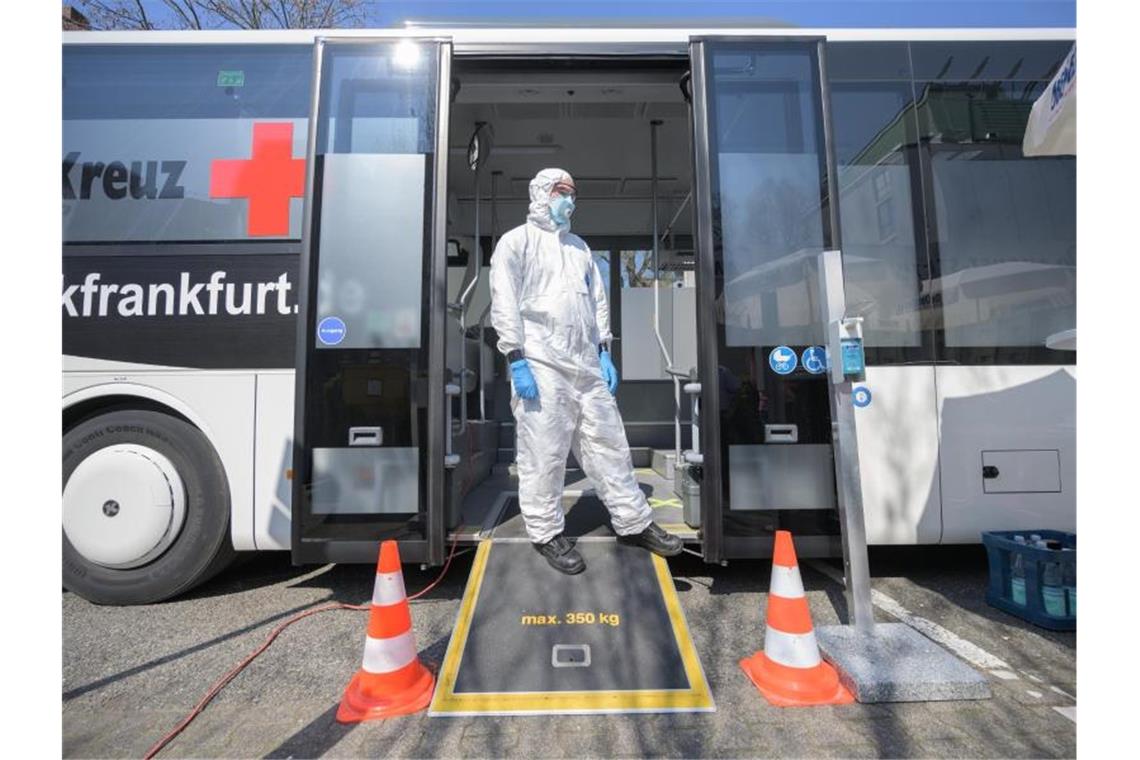 Ein Mitarbeiter steht vor einem Corona-Testmobil in Frankfurt am Main. Foto: Andreas Arnold/dpa