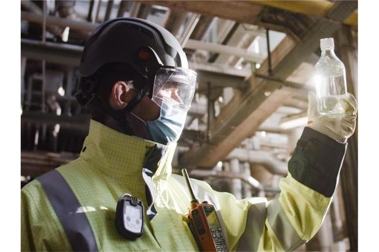 Ein Mitarbeiter von BP begutachtet eine Produktprobe des fertigen Biokerosin-Gemischs. Foto: BP Europa SE/dpa