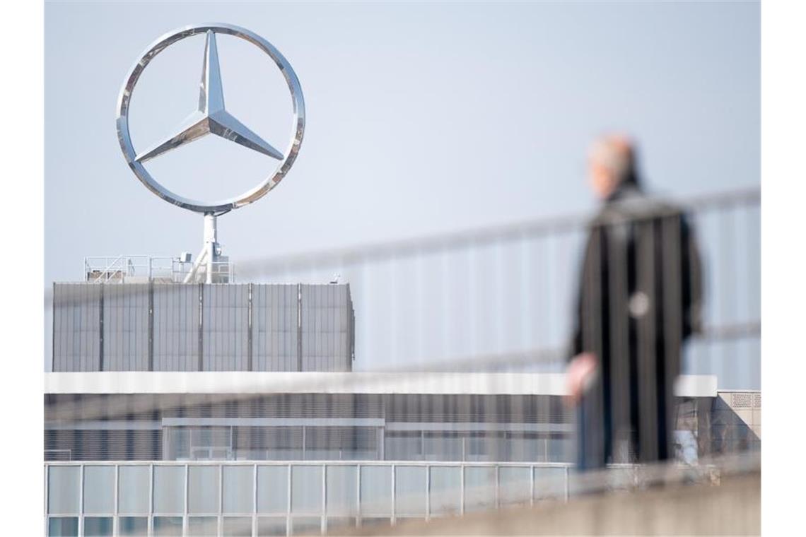 Ein Mitarbeiter von Daimler geht am Mercedes-Benz Werk Untertürkheim. Foto: Sebastian Gollnow/dpa