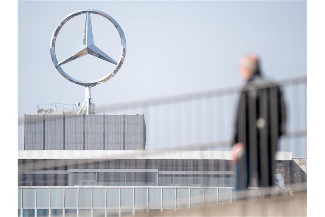 Ein Mitarbeiter von Daimler geht am Mercedes-Benz Werk zum Schichtwechsel. Foto: Sebastian Gollnow/dpa/Symbolbild