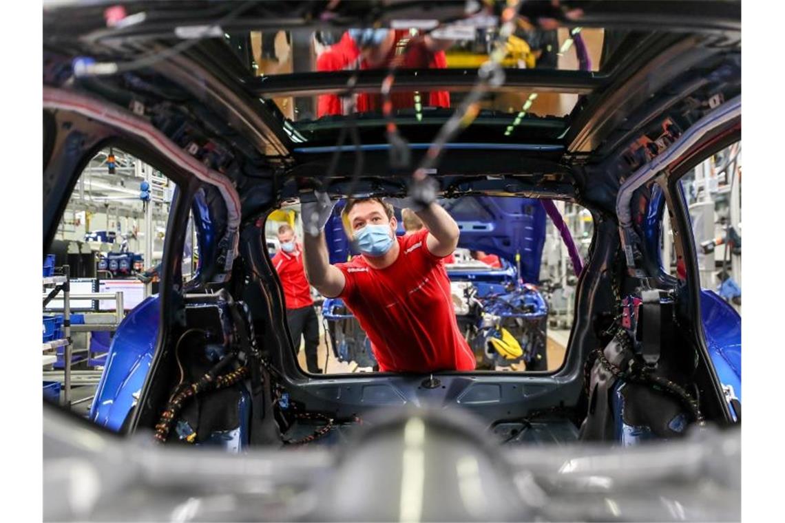 Statistikamt: Deutsche Wirtschaft weiter auf Erholungskurs Ein Mitarbeiter von Porsche arbeitet in der Montage in Leipzig an einem Macan. Foto: Jan Woitas/dpa-Zentralbild/dpa