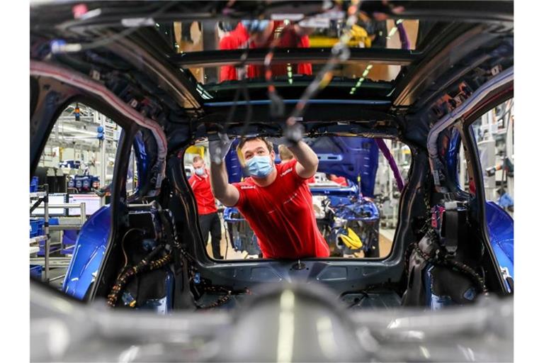 Ein Mitarbeiter von Porsche arbeitet in der Montage in Leipzig an einem Macan. Foto: Jan Woitas/dpa-Zentralbild/dpa