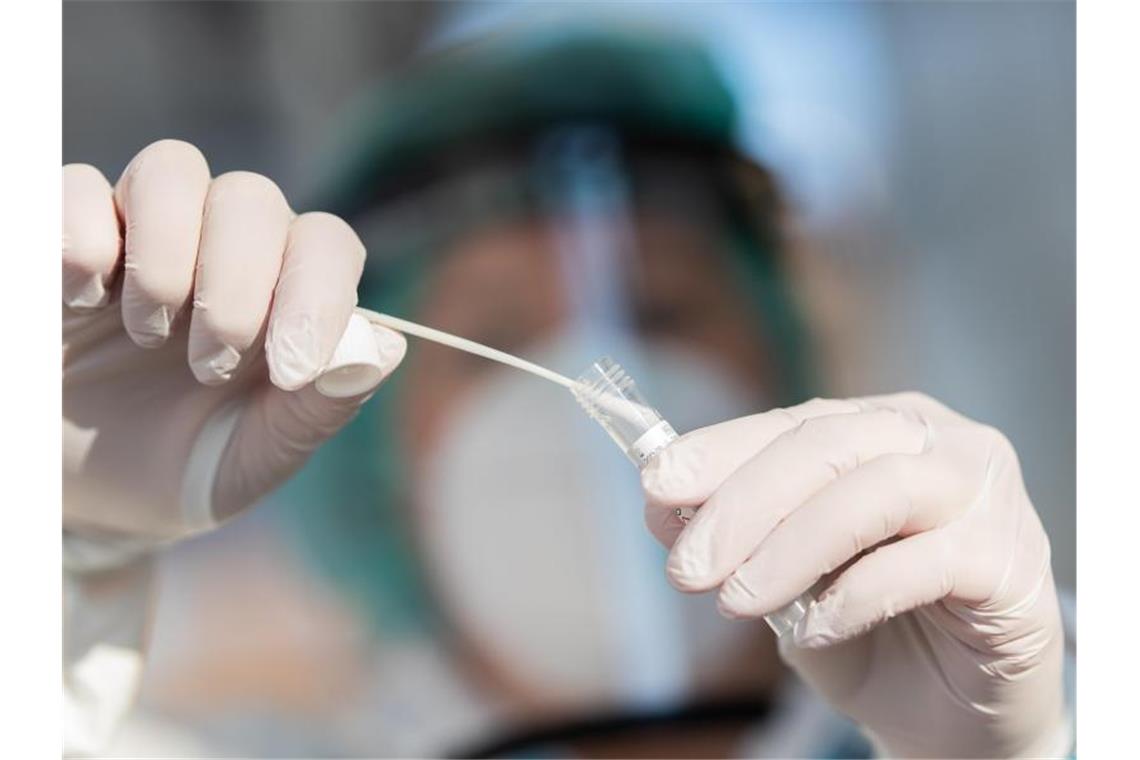 Mehr als 300 000 bestätigte Coronavirus-Infektionen Ein Mitarbeiter zeigt einen Abstrich für einen Corona-Test. Foto: Tom Weller/dpa/Symbolbild