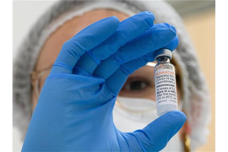 Ein Mitarbeiterin im Impfzentrum hält eine Ampulle mit dem neuen Corona-Impfstoff von Novavax in der Hand. Foto: Robert Michael/dpa-Zentralbild/dpa