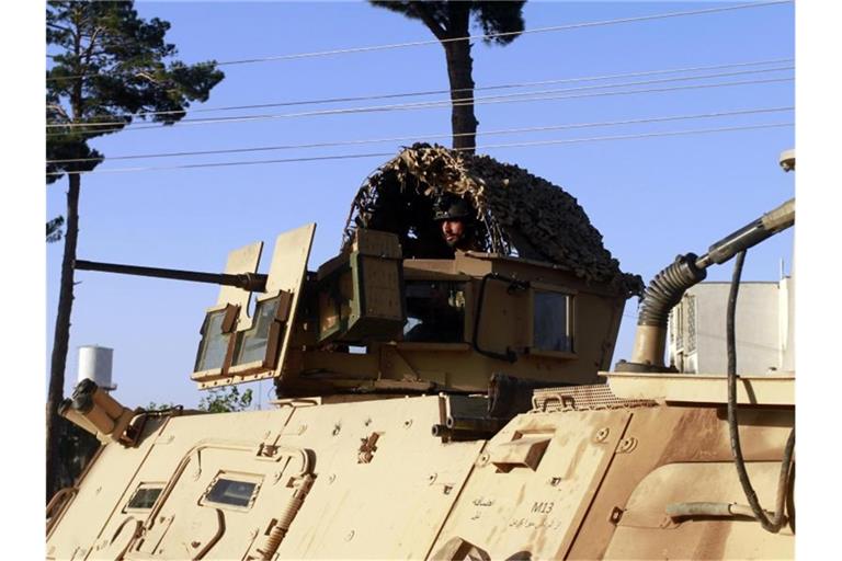 Ein Mitglied der afghanischen Sicherheitskräfte sitzt an einem Geschütz auf einem Fahrzeug während eines Gefechts zwischen Taliban und afghanischen Sicherheitskräften. Foto: Hamed Sarfarazi/AP/dpa