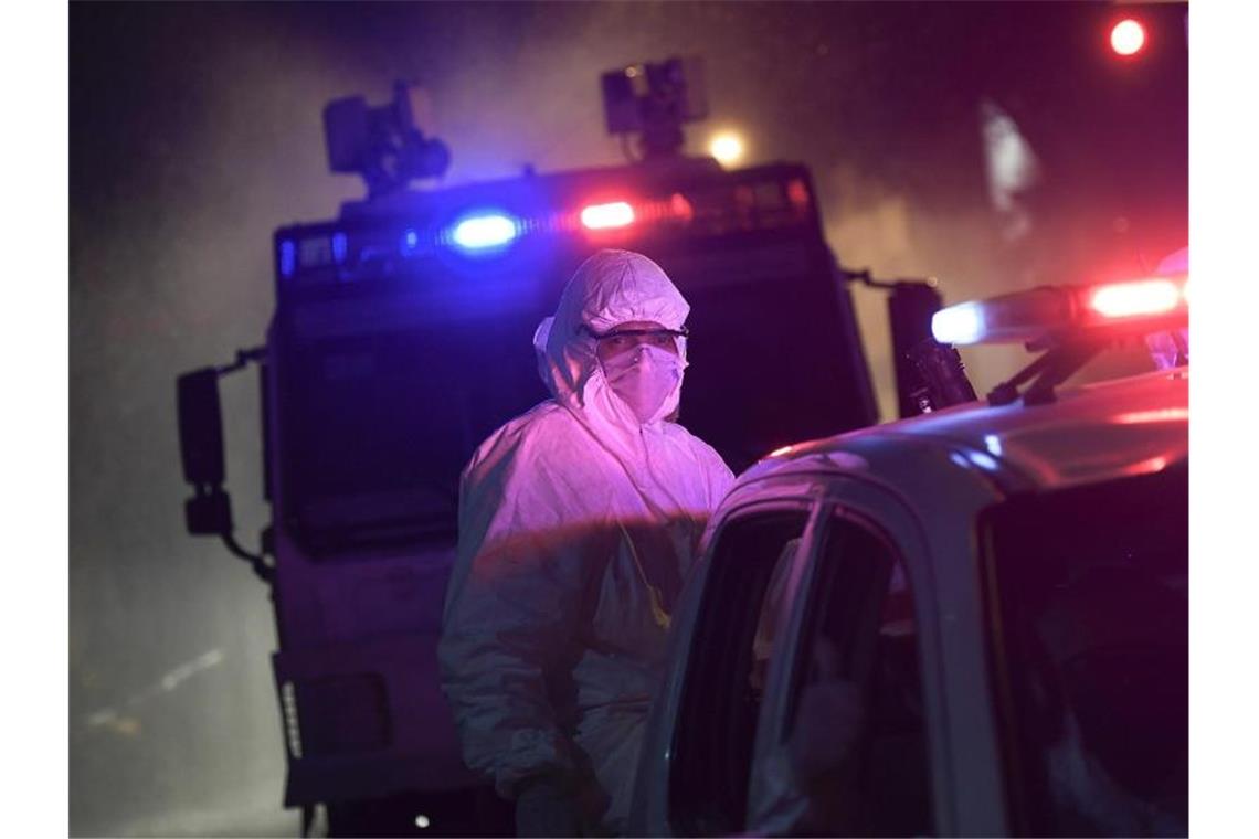 Ein Mitglied der Nationalgarde von Venezuela ist mit einem Schutzanzug in den Straßen von Caracas im Einsatz. Foto: Matias Delacroix/AP/dpa